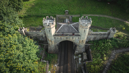 Rail track tunnel with castle looking house on top, in a green hill, East Sussex, UK