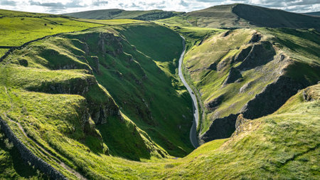 Curvy road between two hills in Yorkshire, Winnats Pass, UKの写真素材