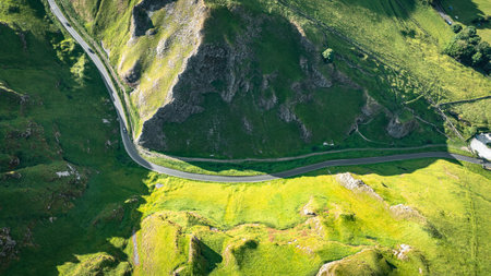 Curvy road between two hills in Yorkshire, Winnats Pass, UKの写真素材