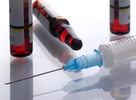 Syringe close-up with vials of medicine on a backgroundの写真素材