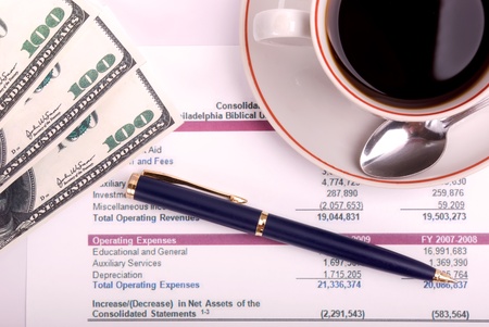 Top view of money,pen,coffee cup and financial report