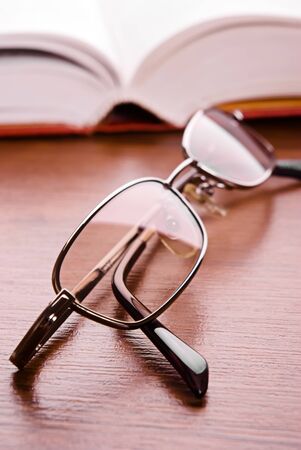 Glasses close up and the open book on a backgroundの写真素材