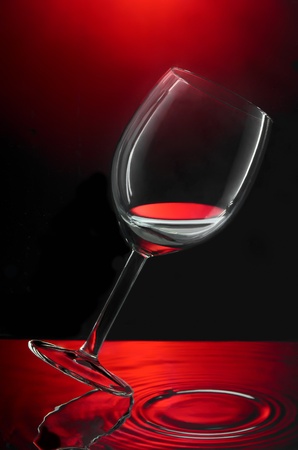 Wineglass on water and a red backdropの写真素材