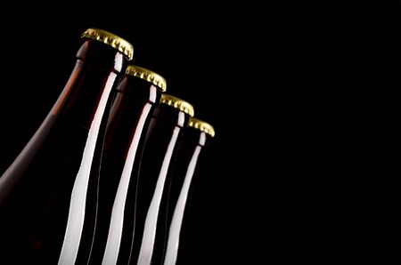 Four bottles of beer on a black backgroundの写真素材