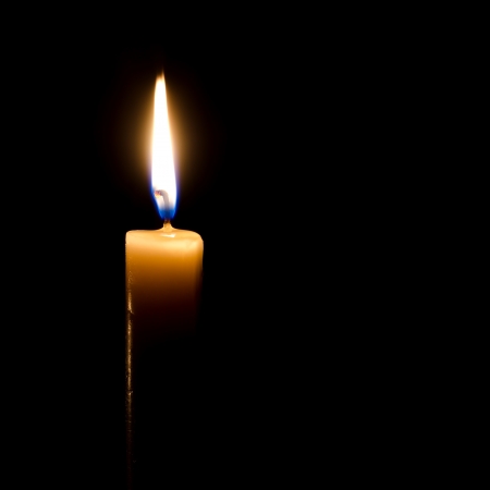 Burning candle on a black background の写真素材