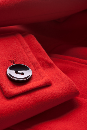 Close-up of button on red coat.の写真素材