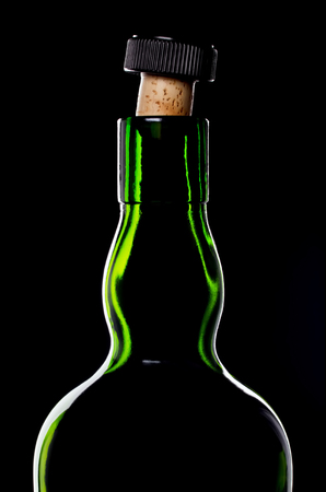 Old-fashioned bottle of whisky with cork on black backgroundの写真素材