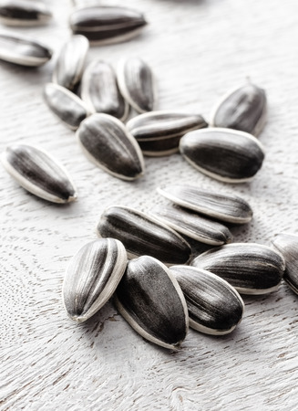 Sunflower seeds closeup on a white woodenの写真素材