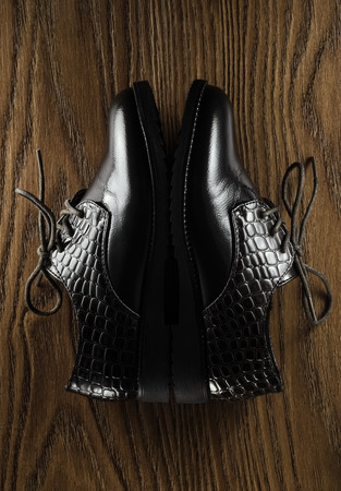 Pair of leather brown shes on wooden floorの写真素材