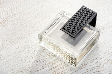 Perfume glass bottle on wooden surface in sunlightの写真素材