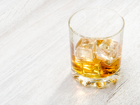 Glass whiskey with ice and in sunlightの写真素材