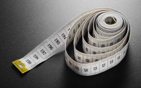 White measurement tapeline with black numbers on a black