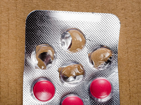 Opened pack of pills on paper backgroundの写真素材