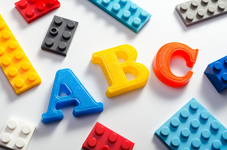 Abc letters and plastic colorful bricks.