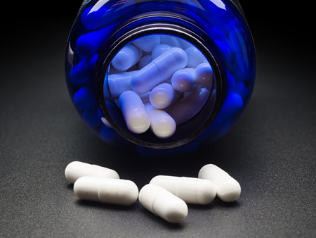 Drug pills from blue bottle.Dietary supplement.の写真素材