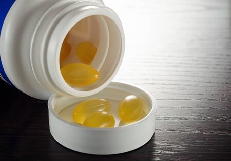 Oil fish pills out a bottle closeup.の写真素材