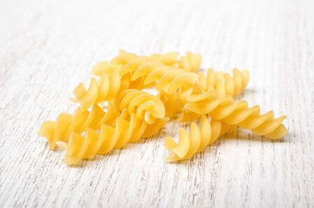 Fusilli macaroni on a white woodの写真素材