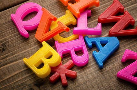 Plastic Letters of English Alphabet on Wood board backgroundの写真素材