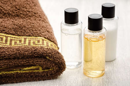 Shampoo and shower gel with towel on a tableの写真素材