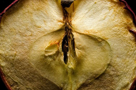 Half old dry apple close-up on black backgroundの写真素材
