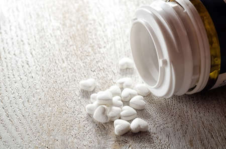 Pills as a heart form closeup on a wooden backgroundの写真素材