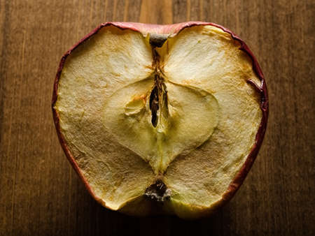 Half old dry apple on wooden backgroundの写真素材