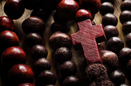 Wooden rosary with christian cross close-up on wooden backgroundの写真素材