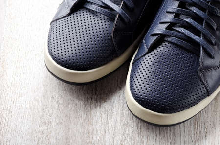 Blue leather sneakers on wooden backgroundの写真素材