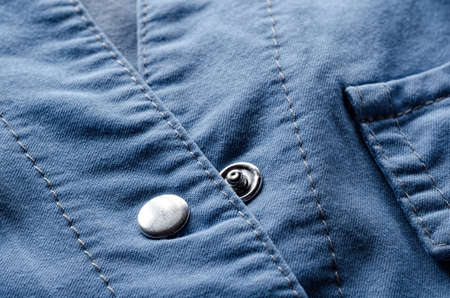 Metallic button on blue cotton shirtの写真素材