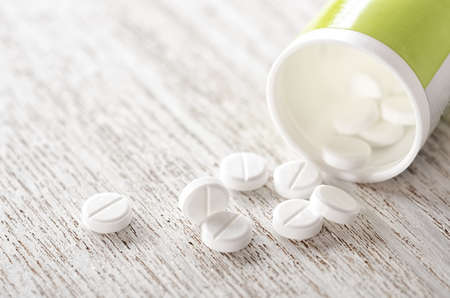 Pills in bottle on wooden background close-upの写真素材