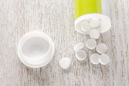 Pills in bottle on wooden background top viewの写真素材