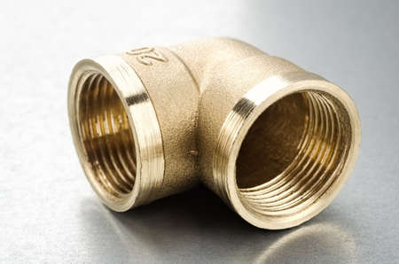 Brass fitting connector on a metallc backgroundの写真素材