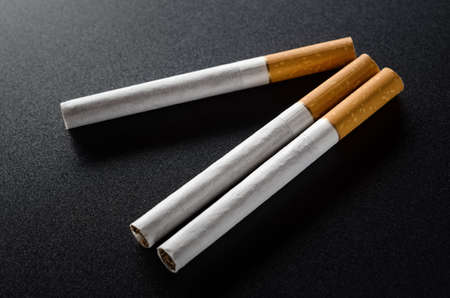 Three cigarettes on a black backgroundの写真素材
