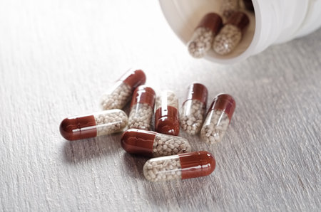 Pills pouring from white bottle close upの写真素材