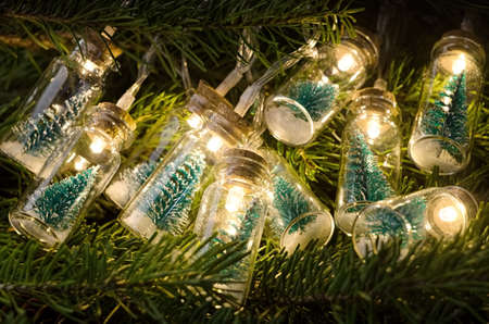 Christmas tree in glass jar glowing on fir needlesの写真素材