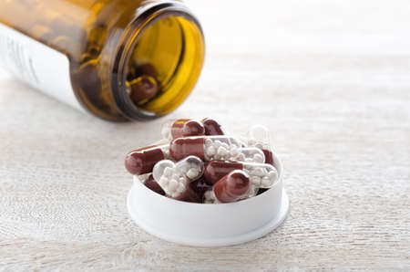 Pills capsules in white cap with bottle close upの写真素材