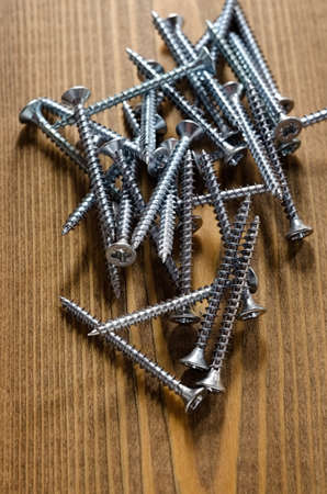 Steel screws on a wooden boardの写真素材