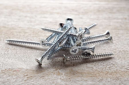 Steel screws on a wooden boardの写真素材
