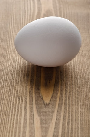 White hen egg on a wooden tableの写真素材