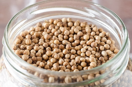 Open jar of Coriander seeds close-upの写真素材