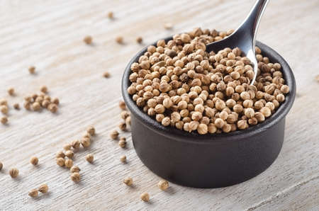 Spoon and bowl of Coriander seeds close-upの写真素材