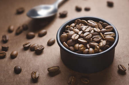 Bowl with coffee beans and spoonの写真素材