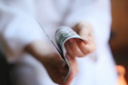 Female hands with dollars on a neutral の写真素材