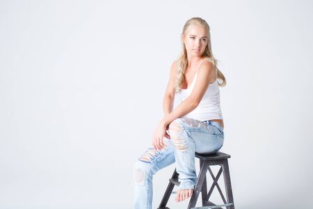 Blonde woman in blue jeans and white shirtの写真素材