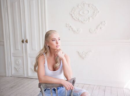 Happy girl in the morning, looks in window, light roomの写真素材