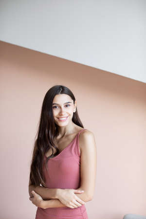 Portrait of beautiful young woman with long hair against wall. people and lifestyle.の写真素材