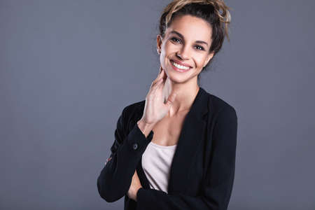 Overjoyed young cute young business woman smiling with joy celebrating win success isolated on gray background. Portrait happy girl.の写真素材