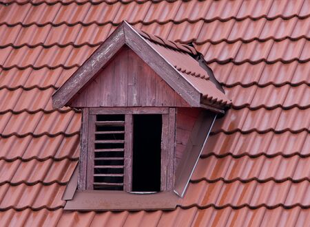 squint window on red roofの写真素材