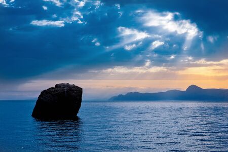 Rock in sea on dark clouds backgroundの写真素材