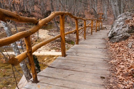 wooden fence in autumn forest near mountain brook